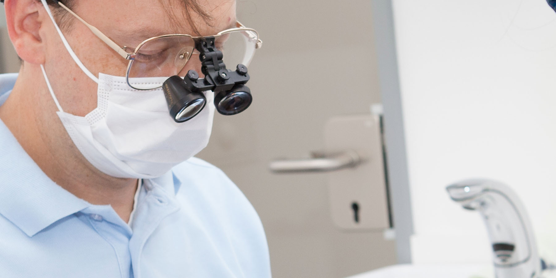 Der Zahnarzt schaut durch eine Zahnarztbrille in der Zahnarztpraxis Dr. Frodl