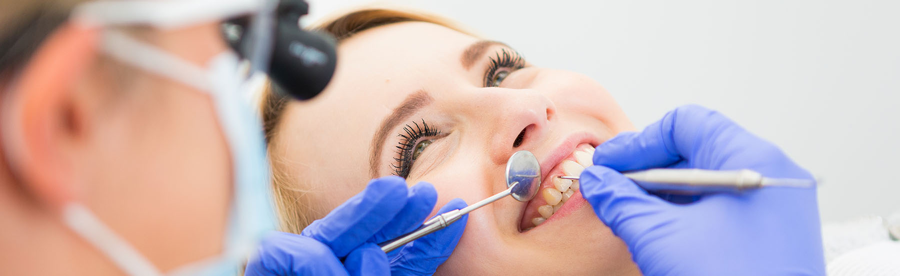 Patientin lächelt während der Zahnreinigung in der Zahnarztpraxis Dr. Frodl