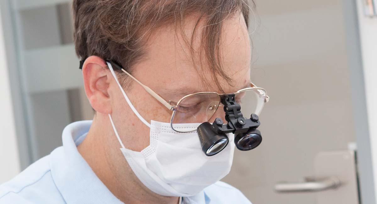 Dr. Andreas Frodl blickt durch eine Zahnarzt-Brille